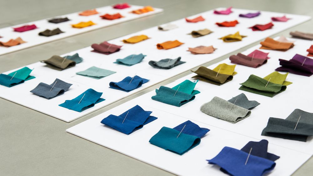 Fabric swatch cards in many colours laid out for uniform fabric and colour selection